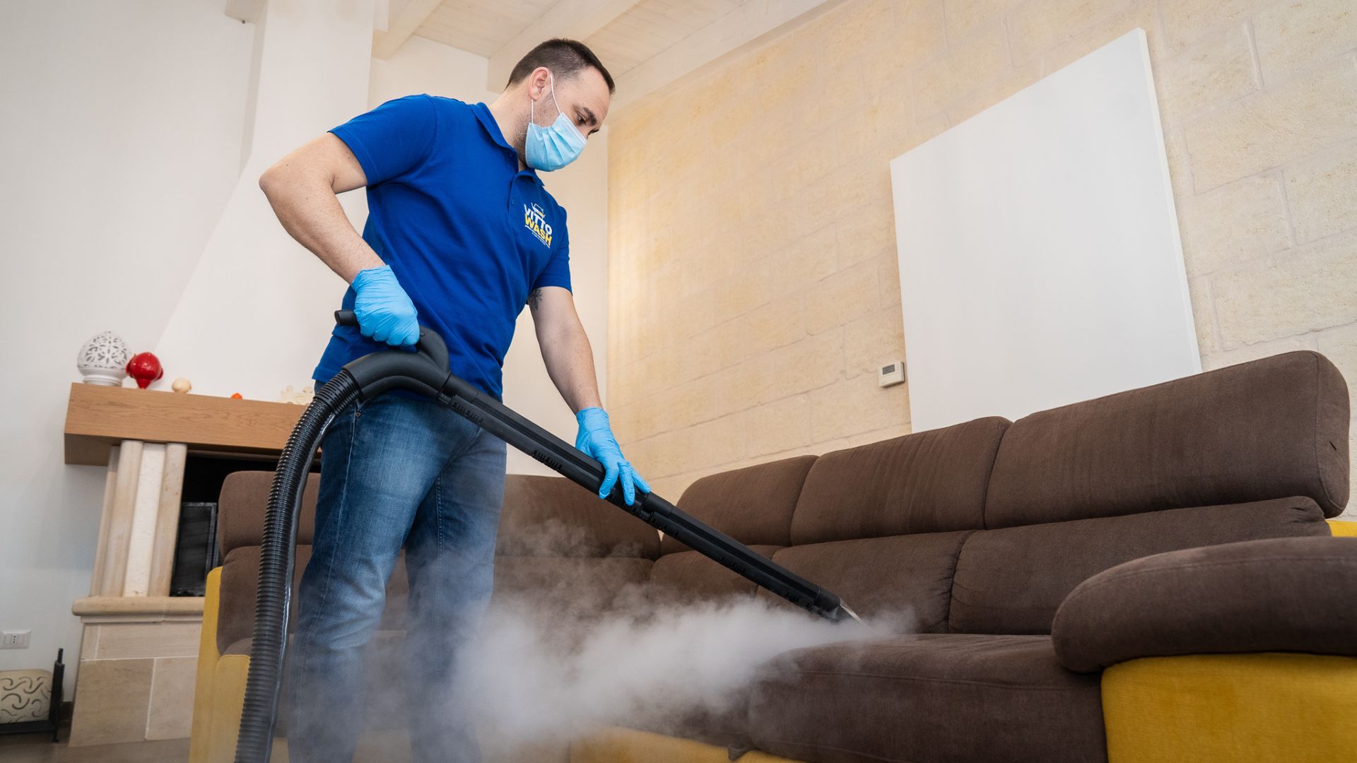 Operatore VittoWash che pulisce un divano a domicilio